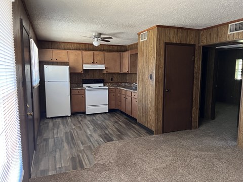 a kitchen with wooden cabinets and a white stove and refrigerator