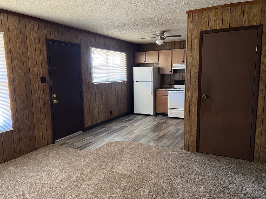 an empty room with a kitchen and a door