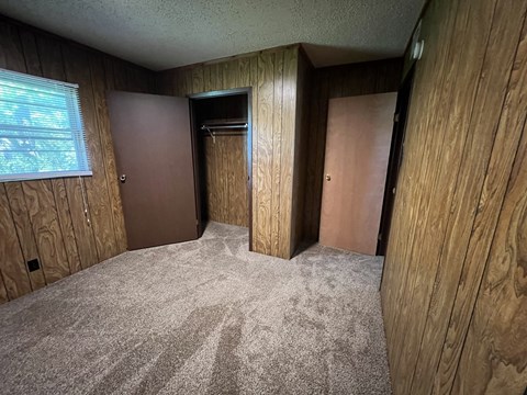 an empty room with two doors and a window