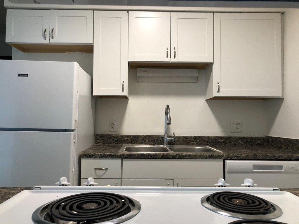 a kitchen with a stove top oven next to a refrigerator