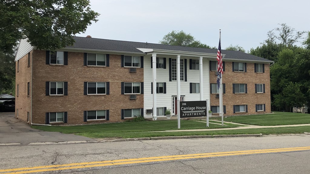 a large brick apartment building with a sign in front of it