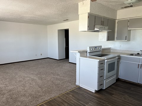 an empty kitchen with white cabinets and a stove top oven