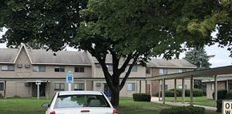 a white car parked in front of an apartment building