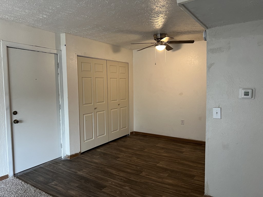 an empty room with a ceiling fan and a door