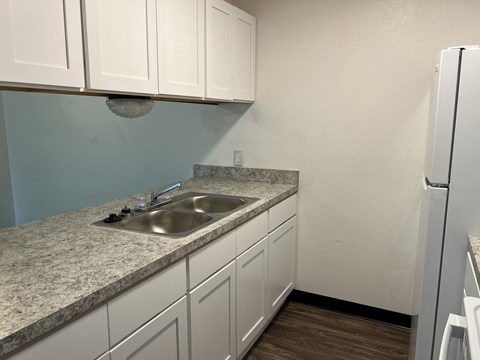 A kitchen with a granite countertop and white cabinets.