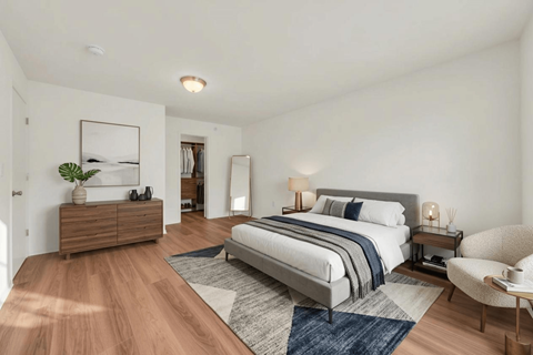 A bedroom with a large bed and a chair.