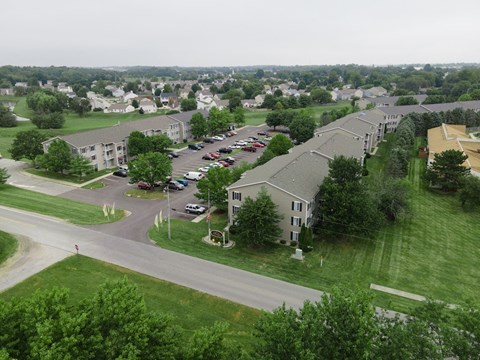 an aerial view of an apartment complex with cars parked in a parking lot