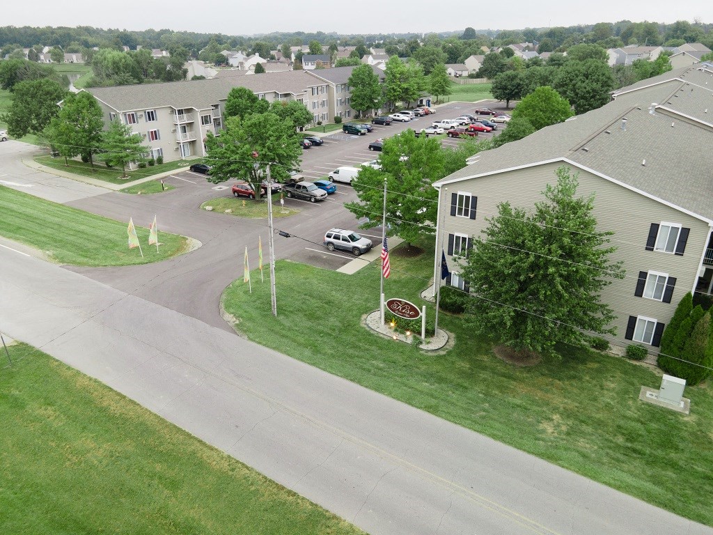 an aerial view of an apartment complex with cars parked in a parking lot