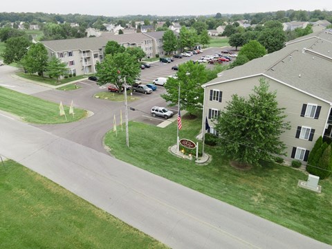 an aerial view of an apartment complex with cars parked in a parking lot