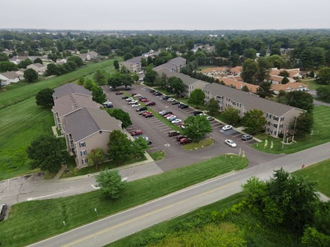 an aerial view of an apartment complex and parking lot