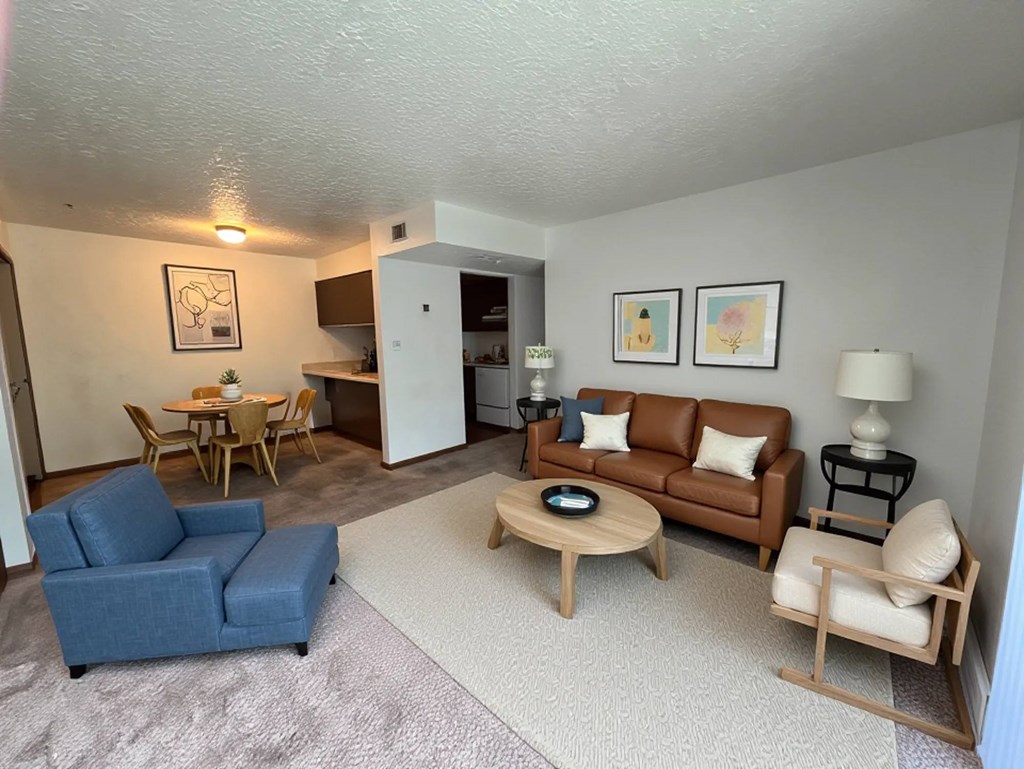 A living room with a blue couch, a wooden coffee table, and a lamp.