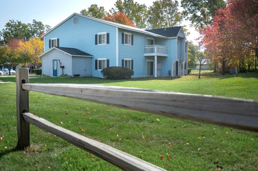 a blue house with a wooden fence in front of it