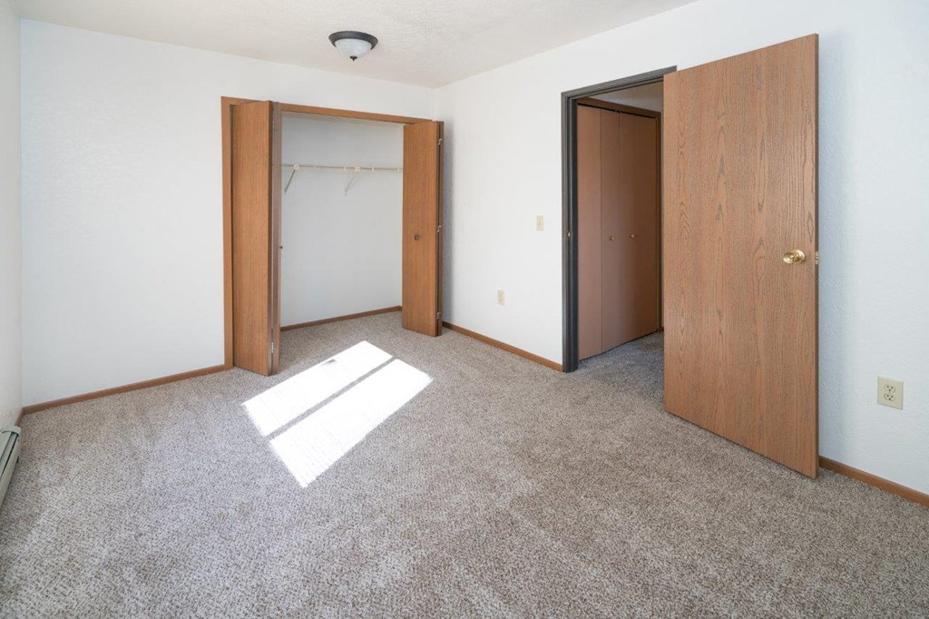 a room with a carpeted floor and two doors