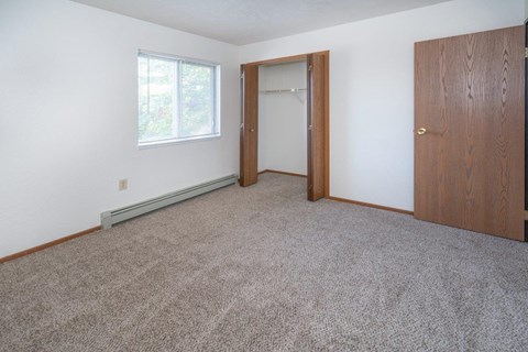 a bedroom with carpet and a door to a closet
