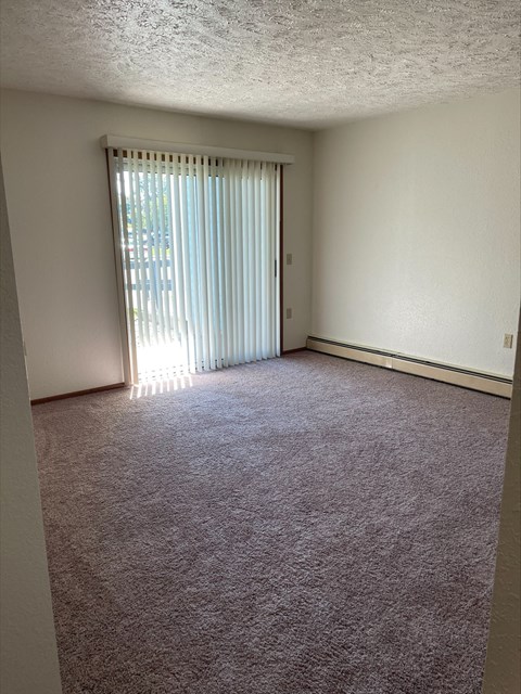 an empty living room with a sliding glass door