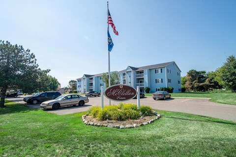 a flag pole with an flag in front of an apartment building