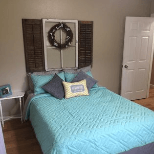 a bedroom with a bed and a wreath on the wall