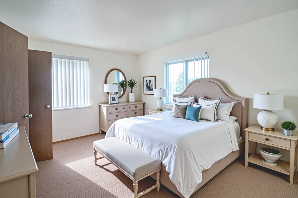 A bedroom with a large bed, a nightstand, and a dresser.