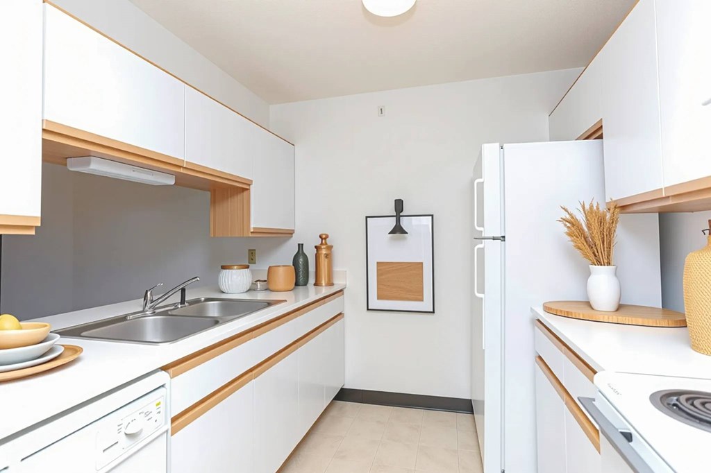 A kitchen with white cabinets and a white fridge.