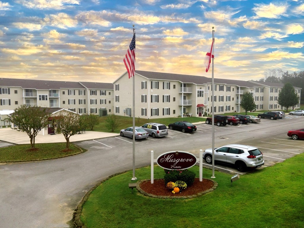 a building with two flags and a sign in front of a parking lot