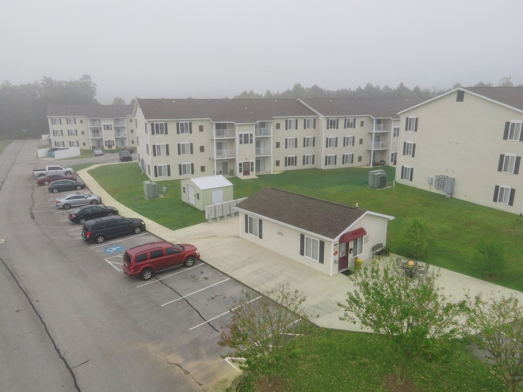 an aerial view of an apartment complex with cars parked in a parking lot