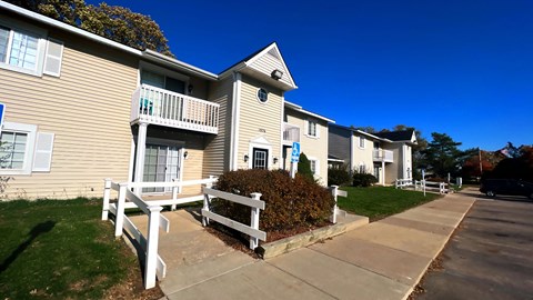 an apartment building with a wooden bench in front of it