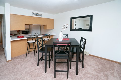 a dining room with a table and chairs and a kitchen