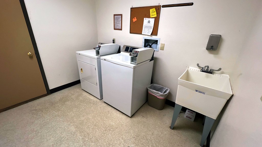 a laundry room with two washing machines and a sink