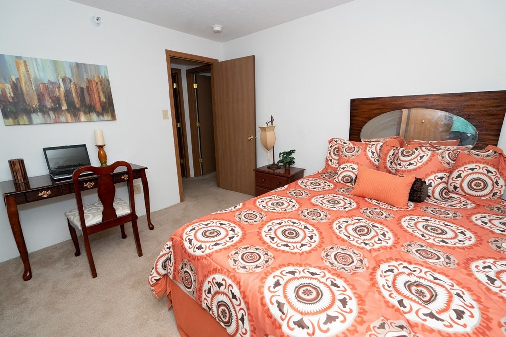 Bedroom with cozy bed and wall frame at Oates Estates Apartments, Alabama, 36303