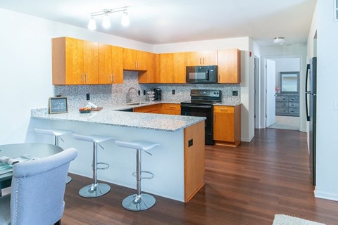 a kitchen with wooden cabinets and a counter top with bar stools