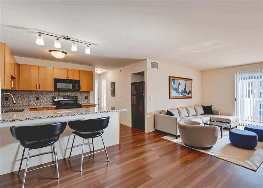A modern kitchen with black chairs and a white countertop.