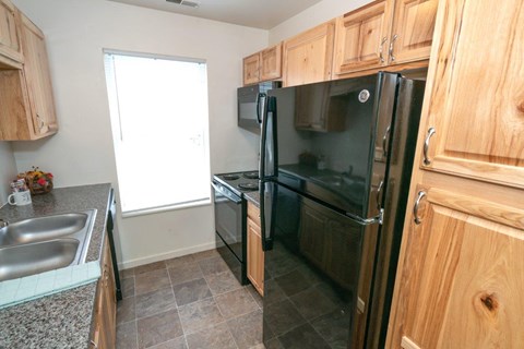 a kitchen with black appliances and wooden cabinets