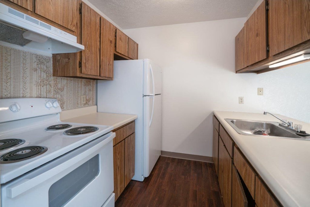 a kitchen with a stove refrigerator and sink