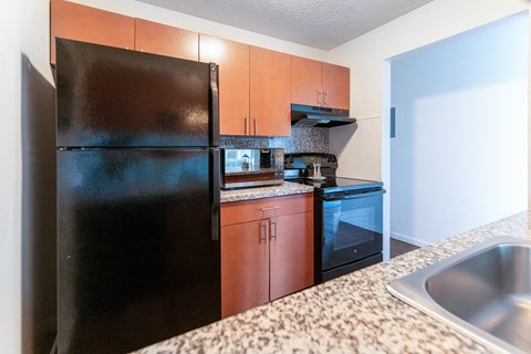 a kitchen with black appliances and granite counter tops