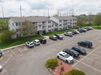 an aerial view of an apartment complex with cars parked in a parking lot