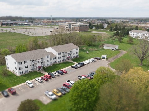 an aerial view of an apartment building and parking lot