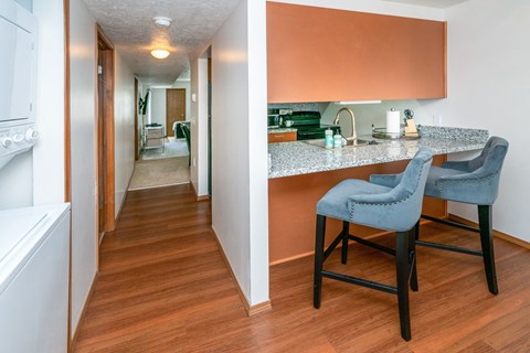 a view of a kitchen and a hallway with a dining room table and chairs