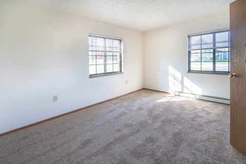 a bedroom with carpet and a door and window