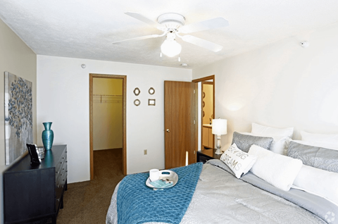 a bedroom with a large bed and a ceiling fan