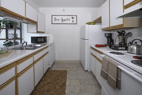 A kitchen with white cabinets and a sign that says "Best Appetite".