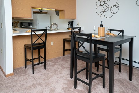 a dining area with a table and chairs and a kitchen