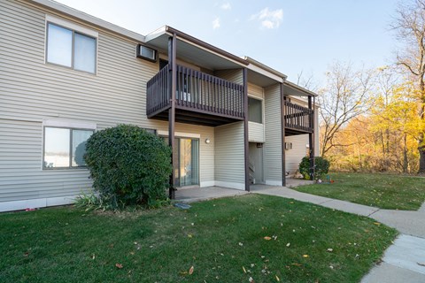 the front of a house with a walkway and grass
