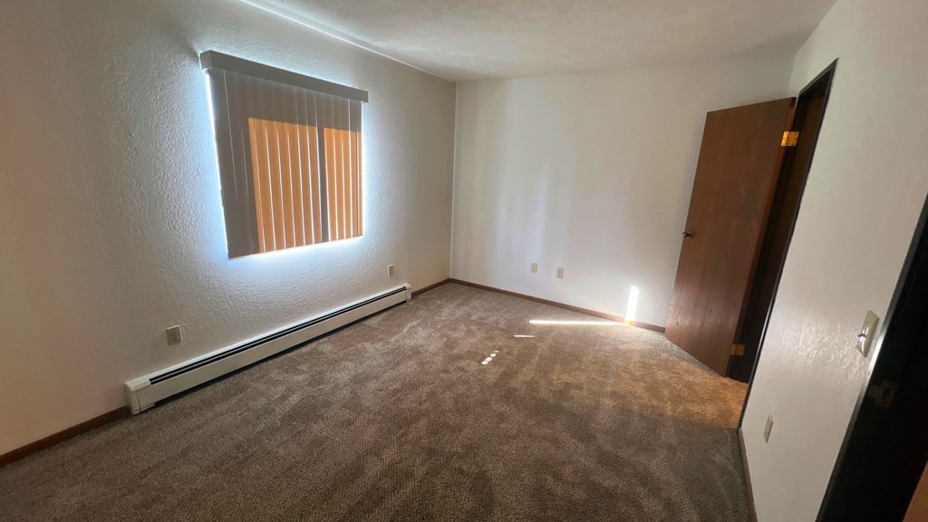 an empty room with carpet and a window