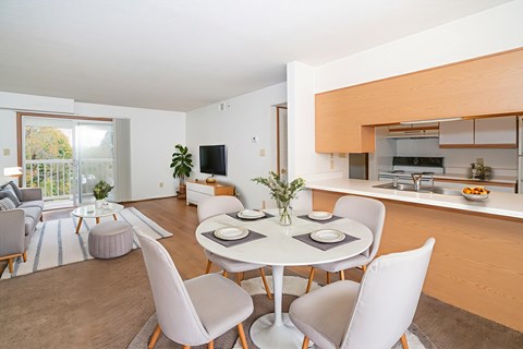 A modern dining room with a white table and chairs.