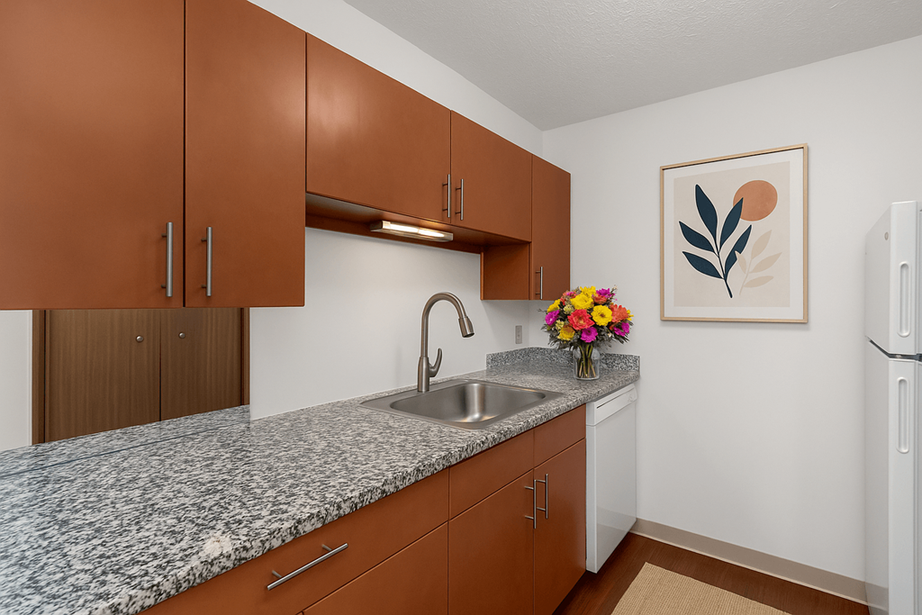 A kitchen with brown cabinets and a granite countertop.