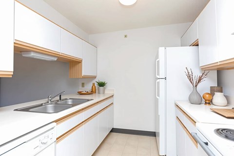 A kitchen with white cabinets and a white refrigerator.