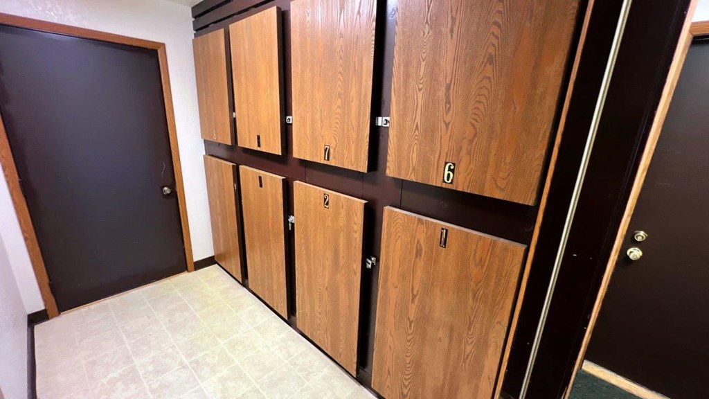 a row of wooden cabinets in a room with black doors