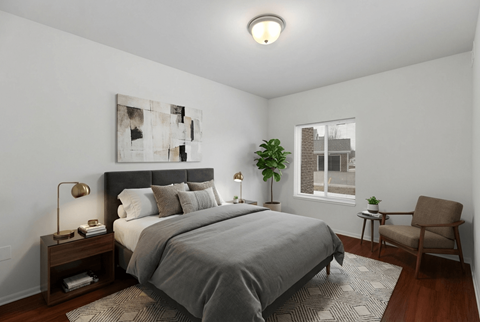 A bedroom with a large bed and a chair.