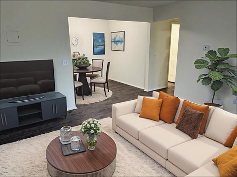 A living room with a white couch and a wooden coffee table.