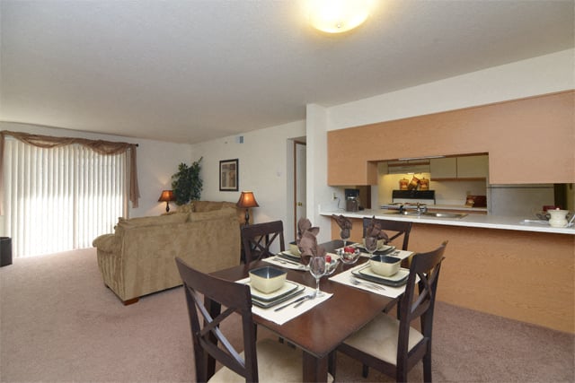 a living room and dining room with a table and chairs
